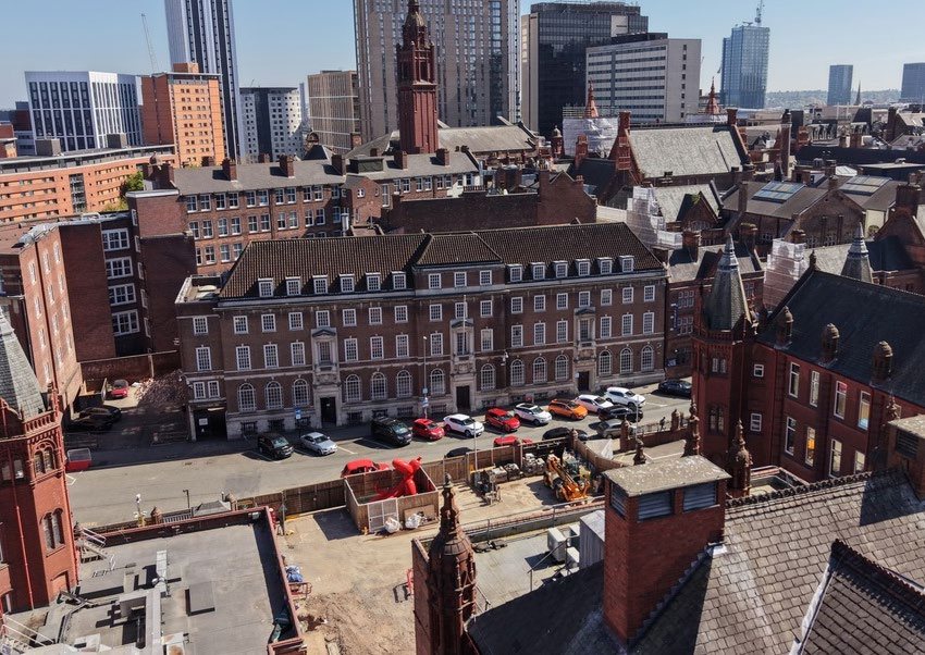 Aerial view of Priors Gate's red-brick roofline with the Birmingham city centre skyline behind